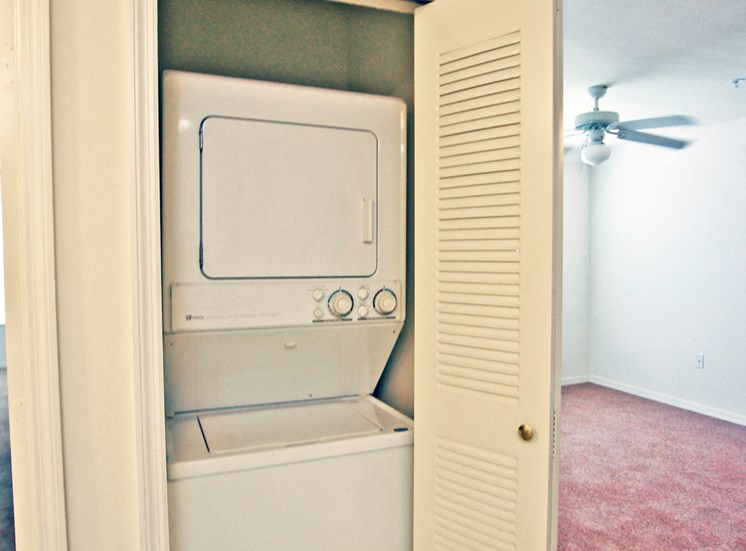 Stackable washer and dryer in laundry room with bifold door